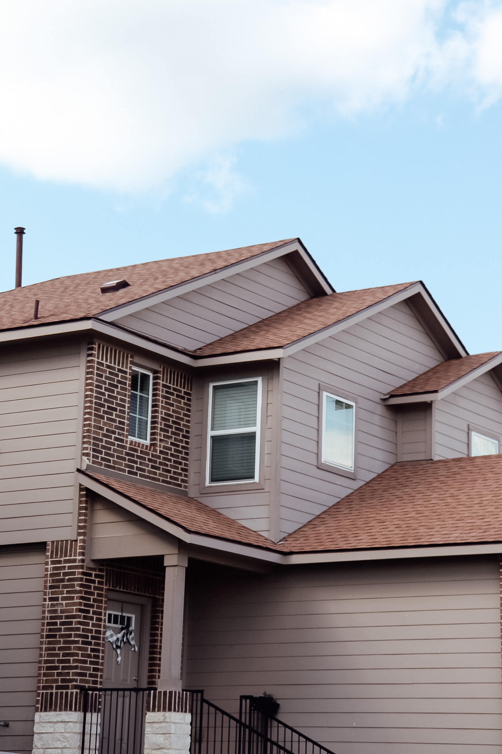 Two-story home with shingle roof